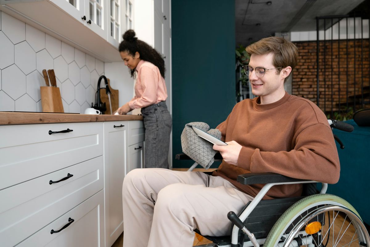 A man in a wheelchair reading at home